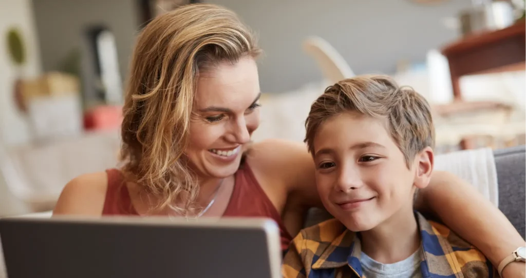 A mother and her son are using a family bonding app on their computer