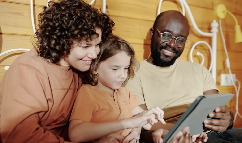 Parents with their child looking at family history on a tablet device