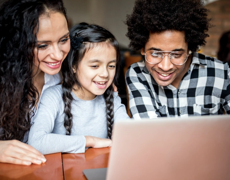 A family, looking at their digital journal on a computer
