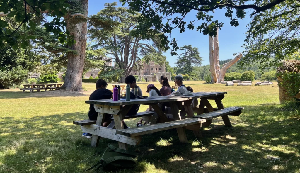 Our family, sat at a picnic table in the shade of a tree