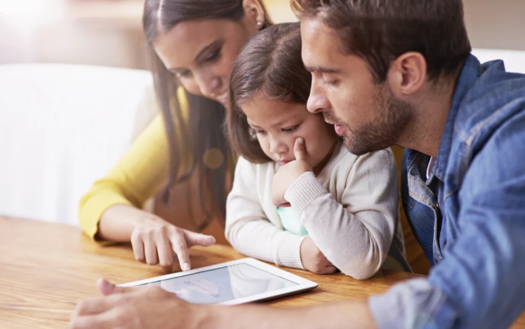 A shared journal being looked at on a tablet by a family