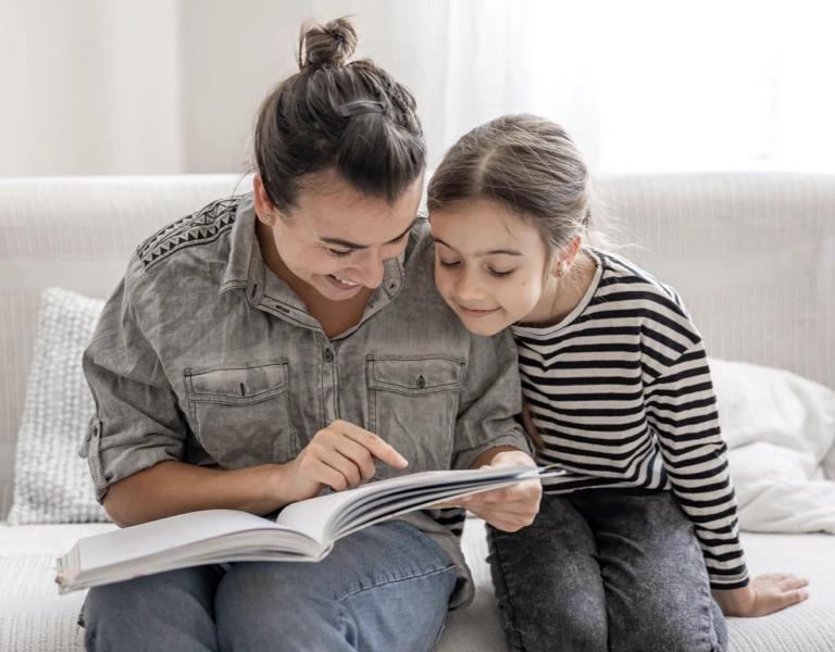 A parent with her daughter reading a family memory journal