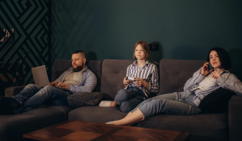 A family spending time together, but everyone is on their own device - no social interaction with each other