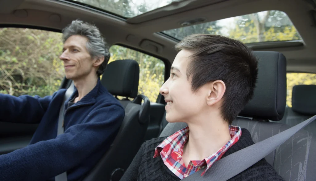 A father with his son having an informal conversation about family values in the car. 