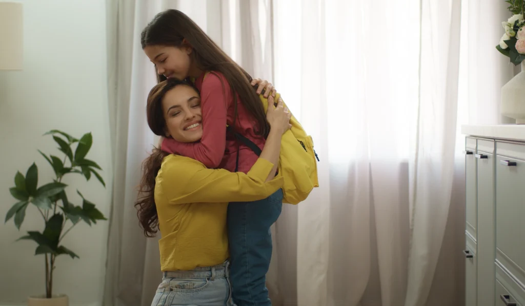 A mother hugging her child as a reward for her behaviour 