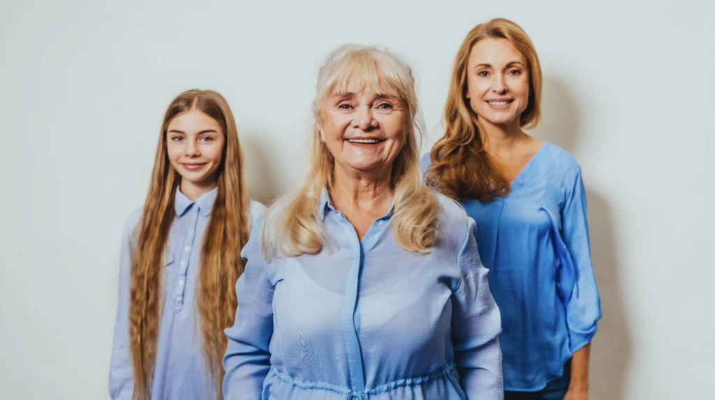 Three generations of women from the same family standing together, representing how traditional family values are passed down from grandparents to parents to children.