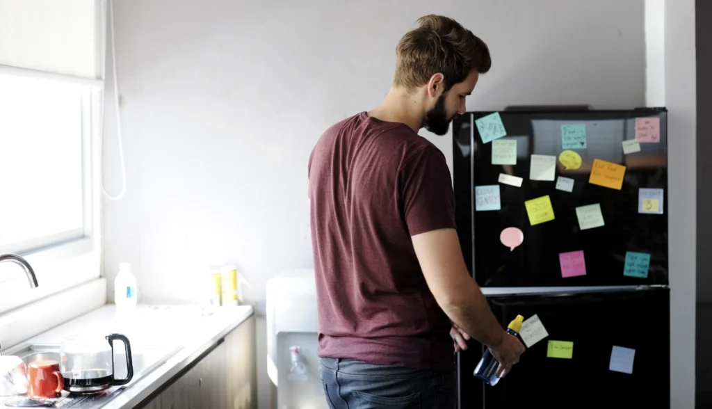 A man in front of a fridge with post-it notes reminding his family about their shared values