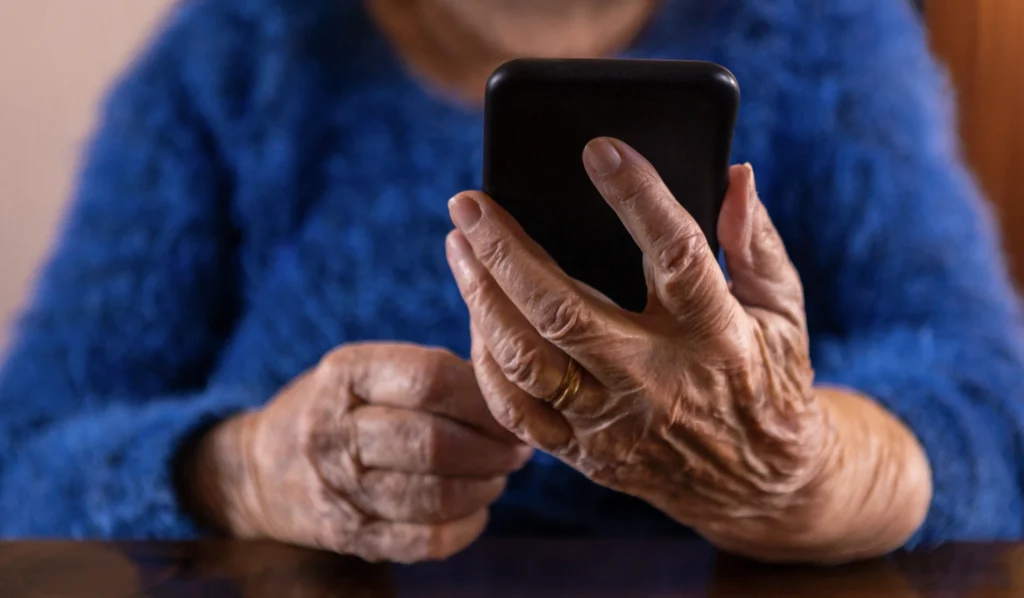 An elderly person looking at a device