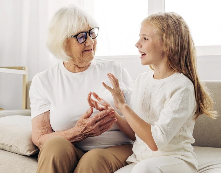 Intergenerational bonding as a teenager talks animatedly to her grandmother