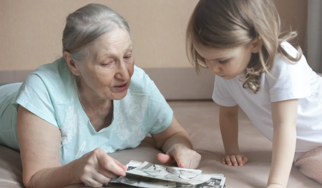 A grandmother showing her granddaughter old family photos 