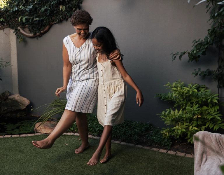 A grandmother teaches her granddaughter a dance move.